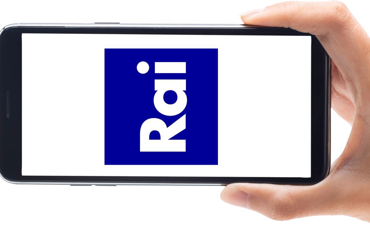 Persona che tiene uno smartphone in mano su cui campeggia il logo Rai