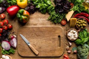 Tagliere sul tavolo con coltello e svariati tipi di verdure