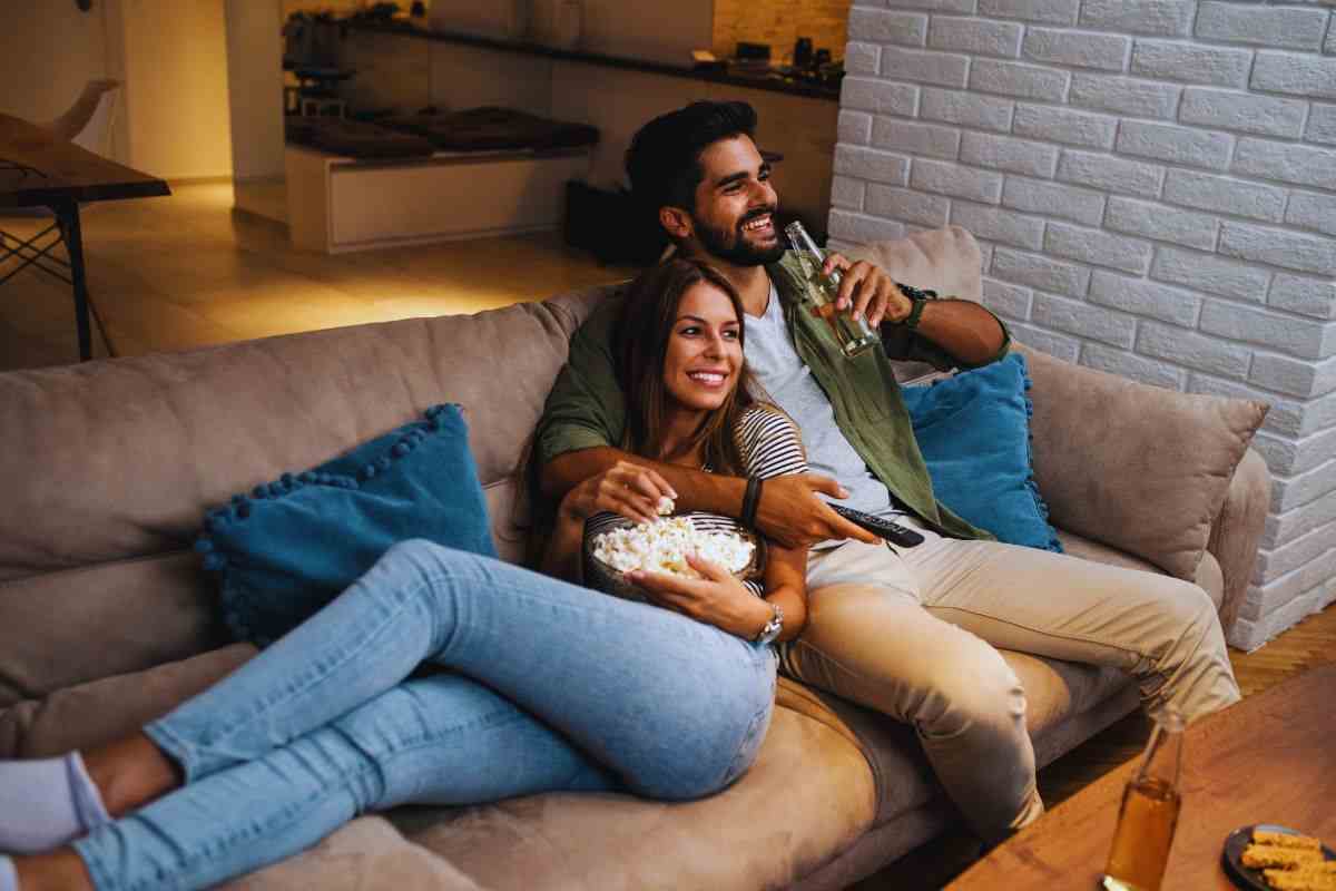 Coppia sul divano che guarda la tv
