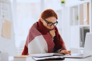 Donna in preda al freddo che si copre con una coperta