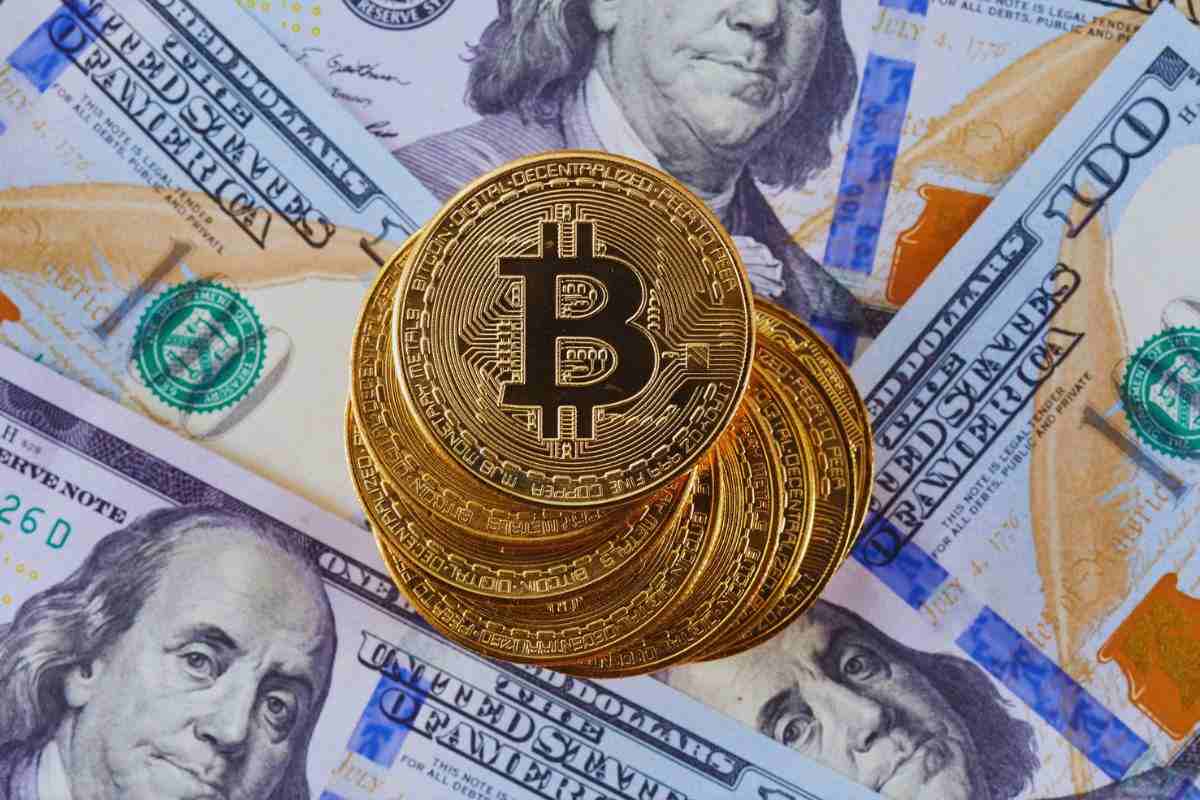 Bitcoin poggiati sopra banconote