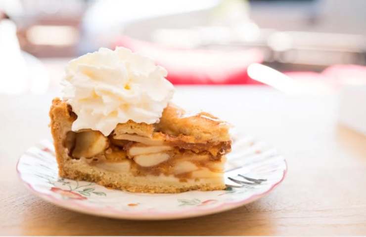 fetta di torta di mele con panna nel piatto 