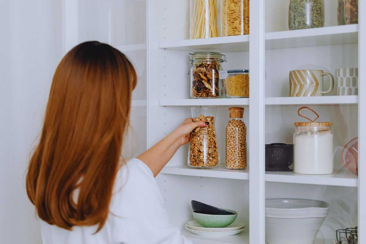Donna che prende barattolo di frutta secca dalla dispensa
